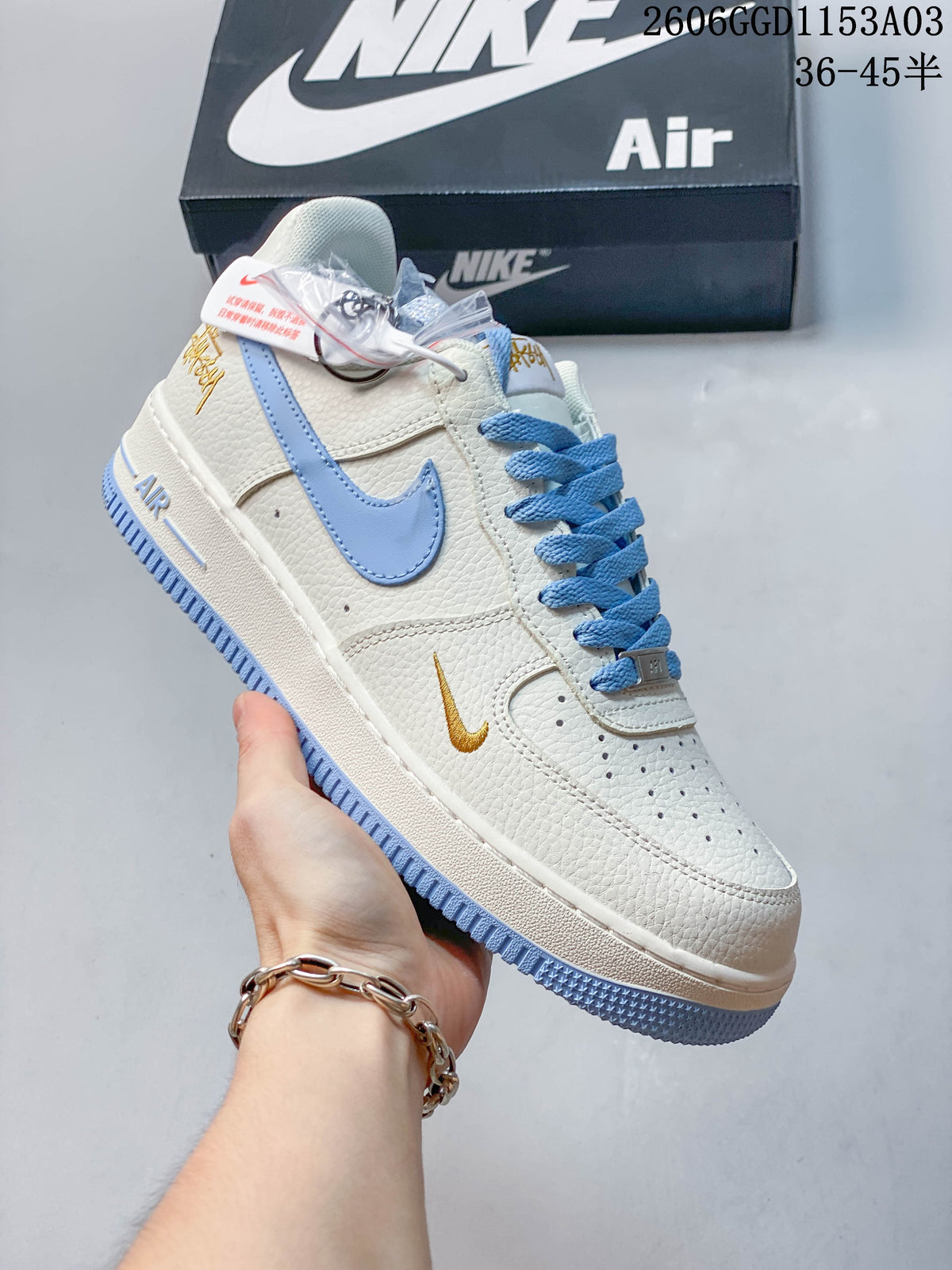 Angled side view of an off-white low-top sneaker with light blue details and gold-tone accents