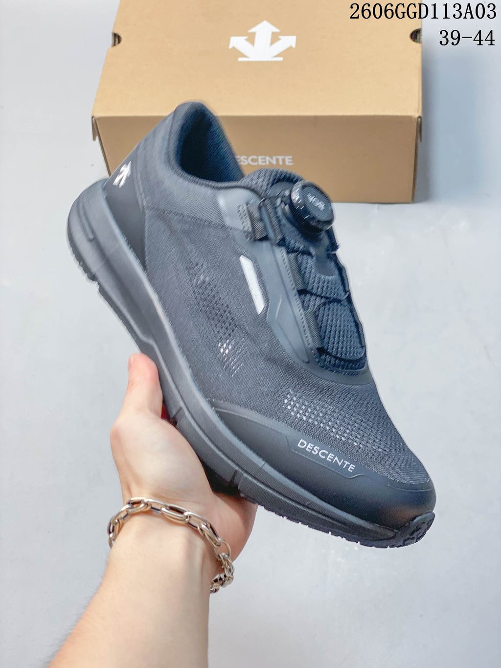 Angled side view of a gray DESCENTE shoe with a dial closure