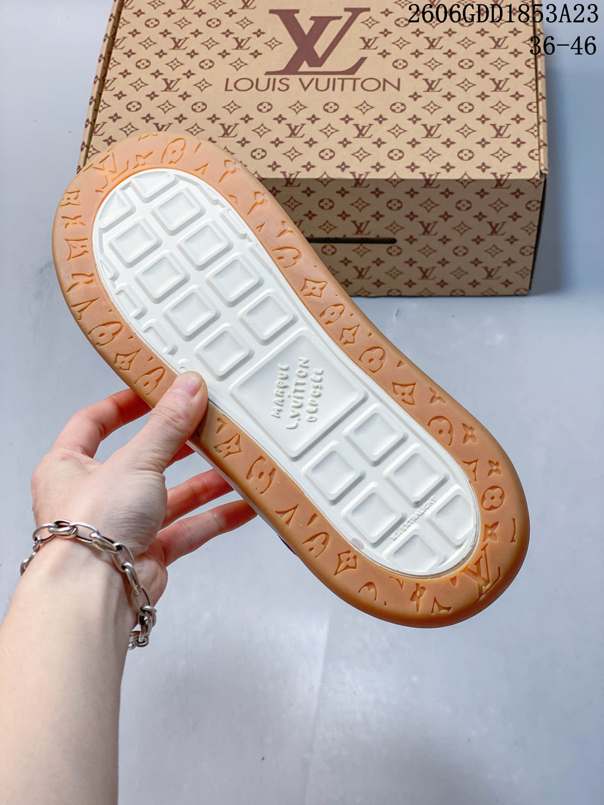 Underside of the sneaker showing a white tread center and gum-colored patterned border