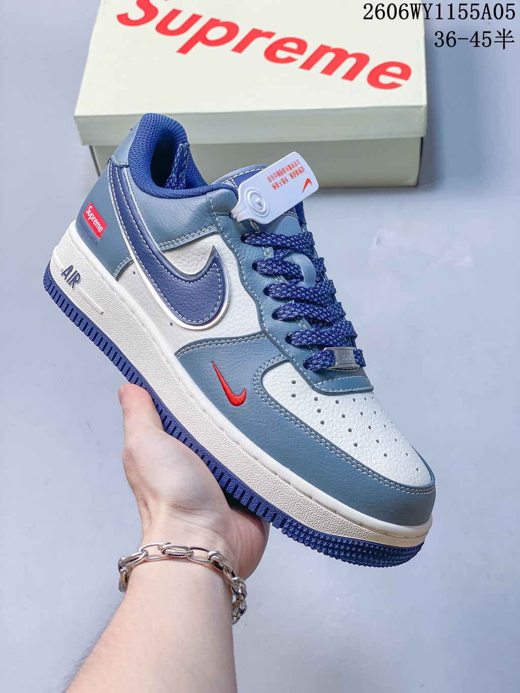 Angled view of the white and blue sneakers with red accents