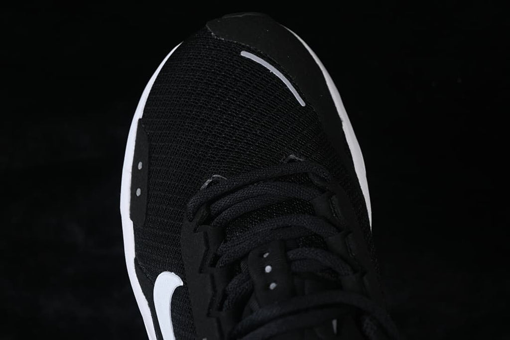 Top-down close-up of the black mesh-look toe and lacing.