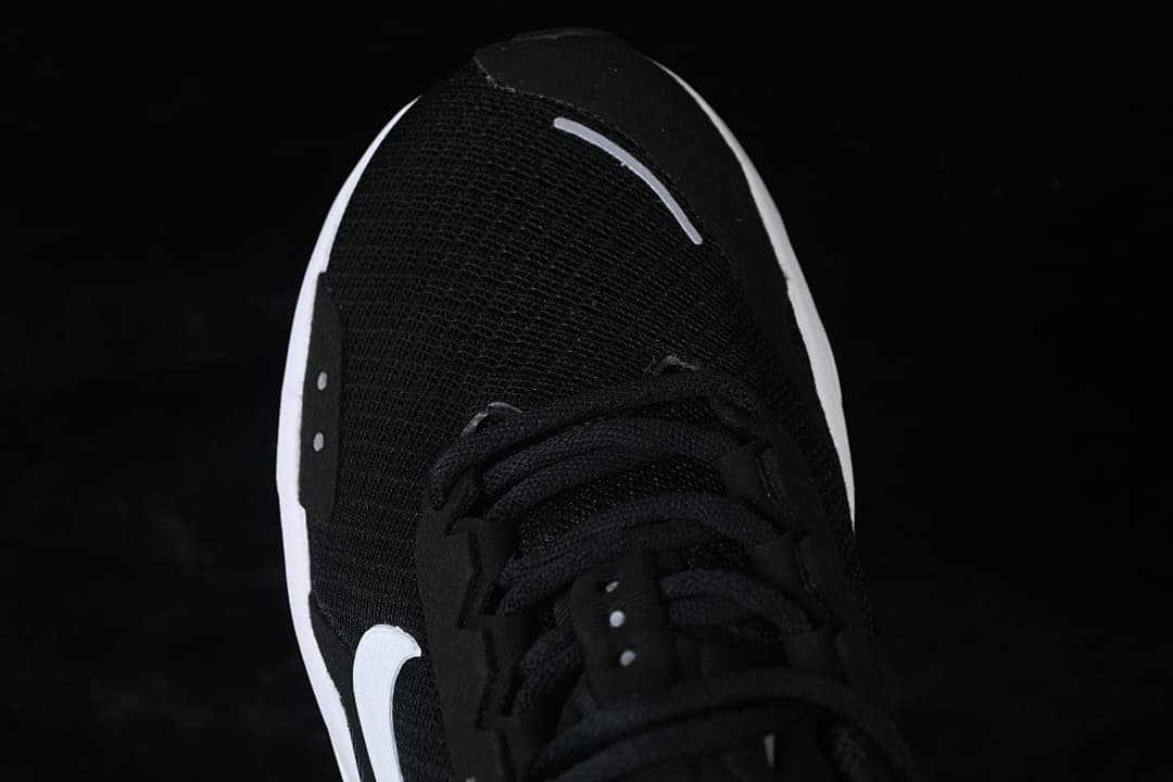 Top-down close-up of the black mesh-look toe and lacing.