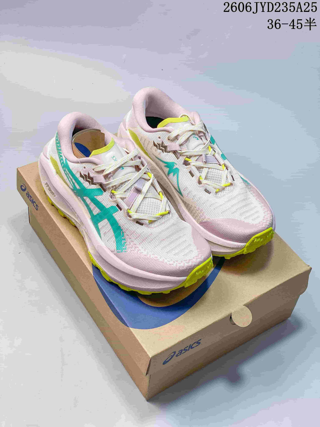 Pair of light pink ASICS GEL-TRABUCO MAX 5 shoes with teal and yellow accents on a shoe box.