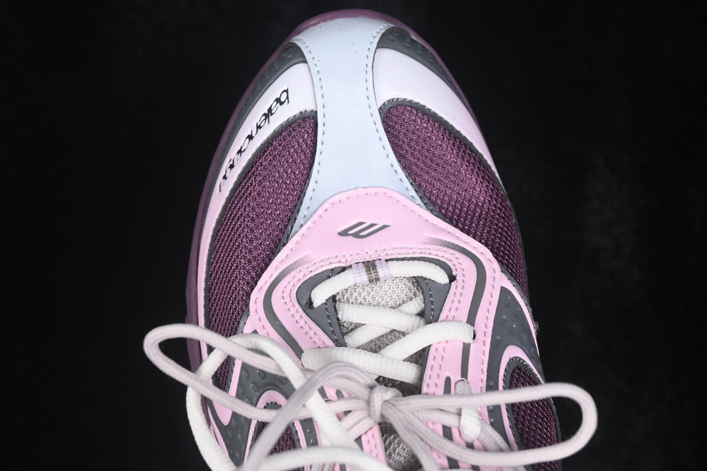 Top-down close-up of the rounded toe, white laces, pink overlays, and purple mesh panels.