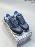 Pair of navy and gray Premiata low-top trainers shown from above on a patterned shoe box