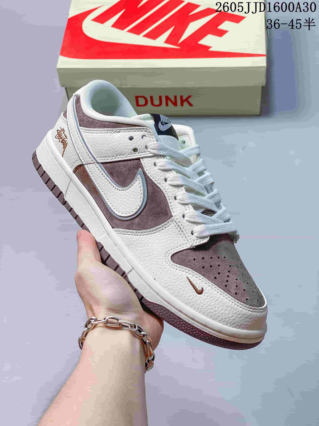 Angled side view of the off-white and mauve-brown low-top sneaker