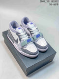 Pair of grey, black, and white Jordan Legacy 312 Low sneakers viewed from the front on a shoebox.