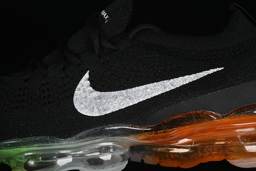 Close-up of the black knit upper, white Swoosh, and transparent multicolor sole.