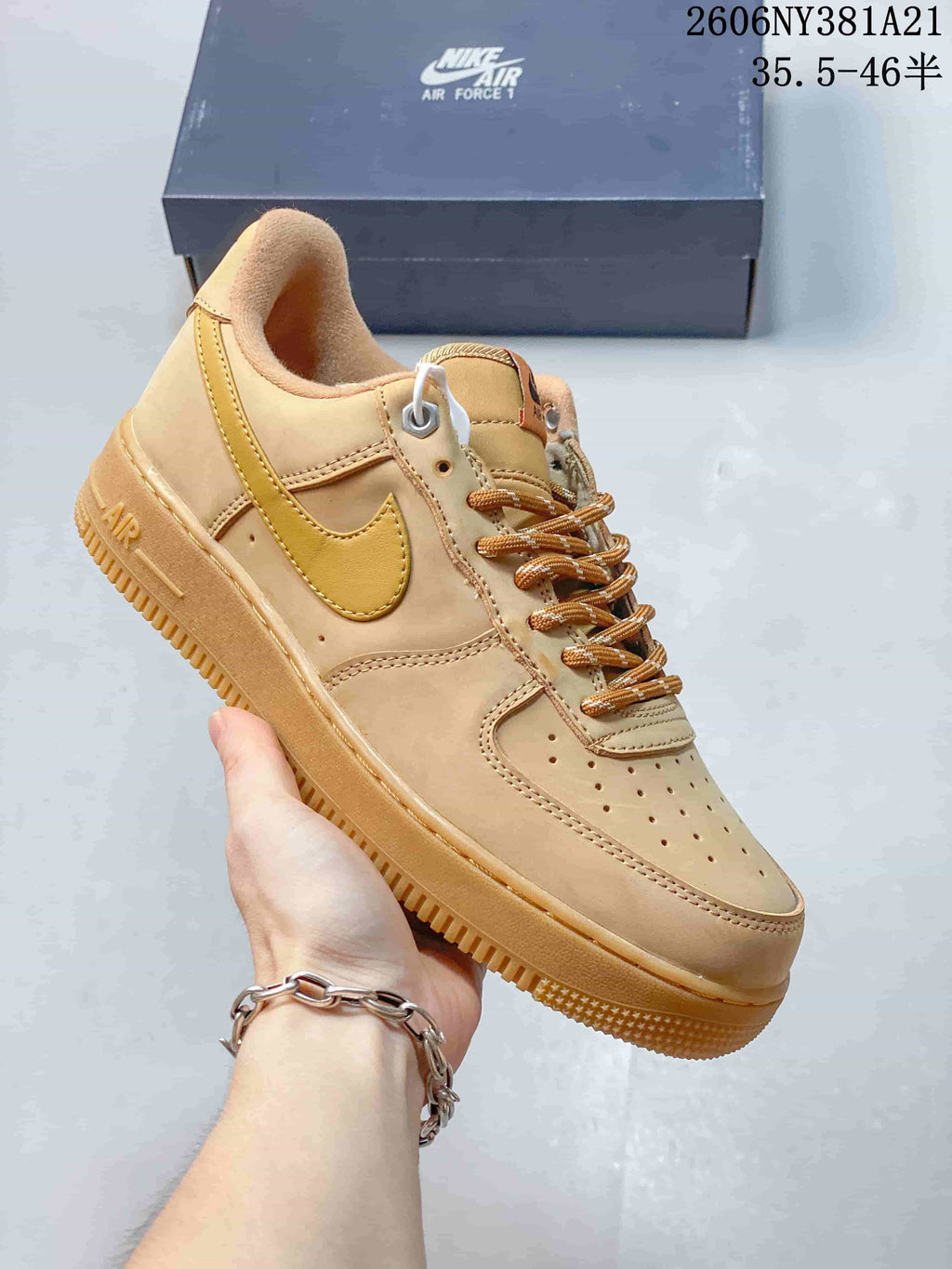 Angled side view of the tan sneaker with a golden-yellow Swoosh and low-top profile