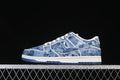 Side view of a blue denim-pattern Nike SB Dunk Low sneaker with white trim and dark blue outsole