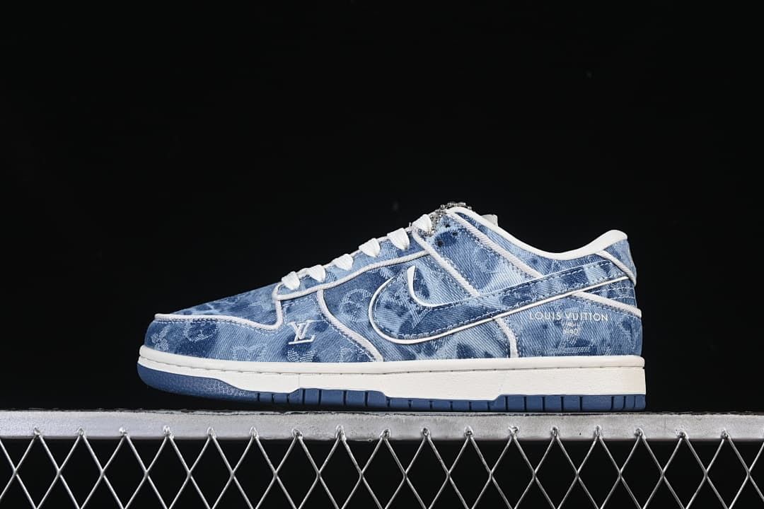 Side view of a blue denim-pattern Nike SB Dunk Low sneaker with white trim and dark blue outsole