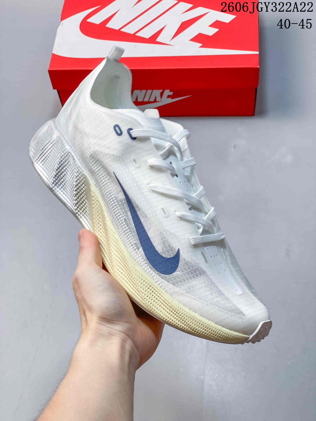 Angled side view of a white Nike Ava X low-top shoe with blue Swoosh.