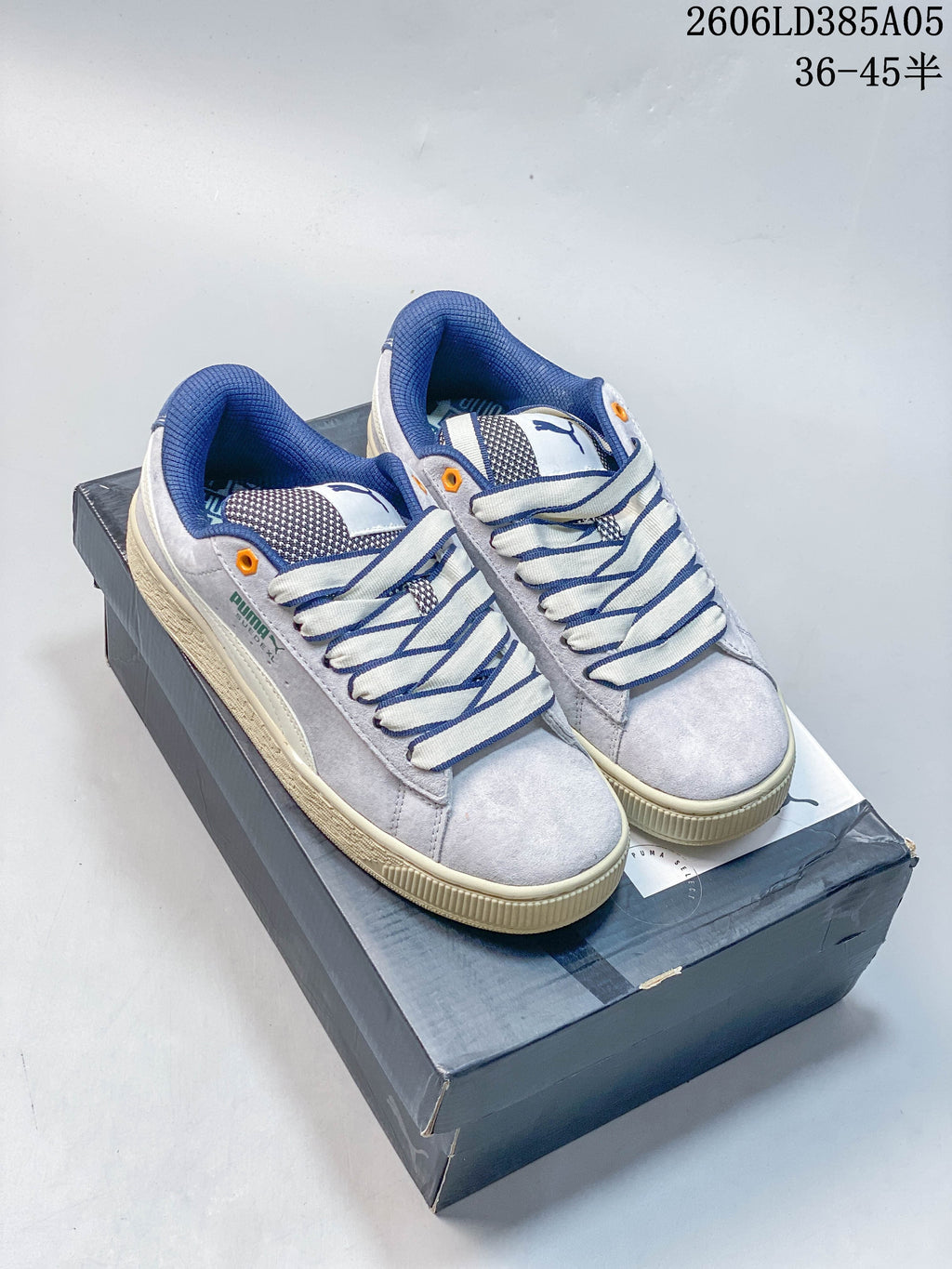 Pair of gray and blue PUMA Suede XL sneakers with wide contrast laces and chunky cream-colored soles