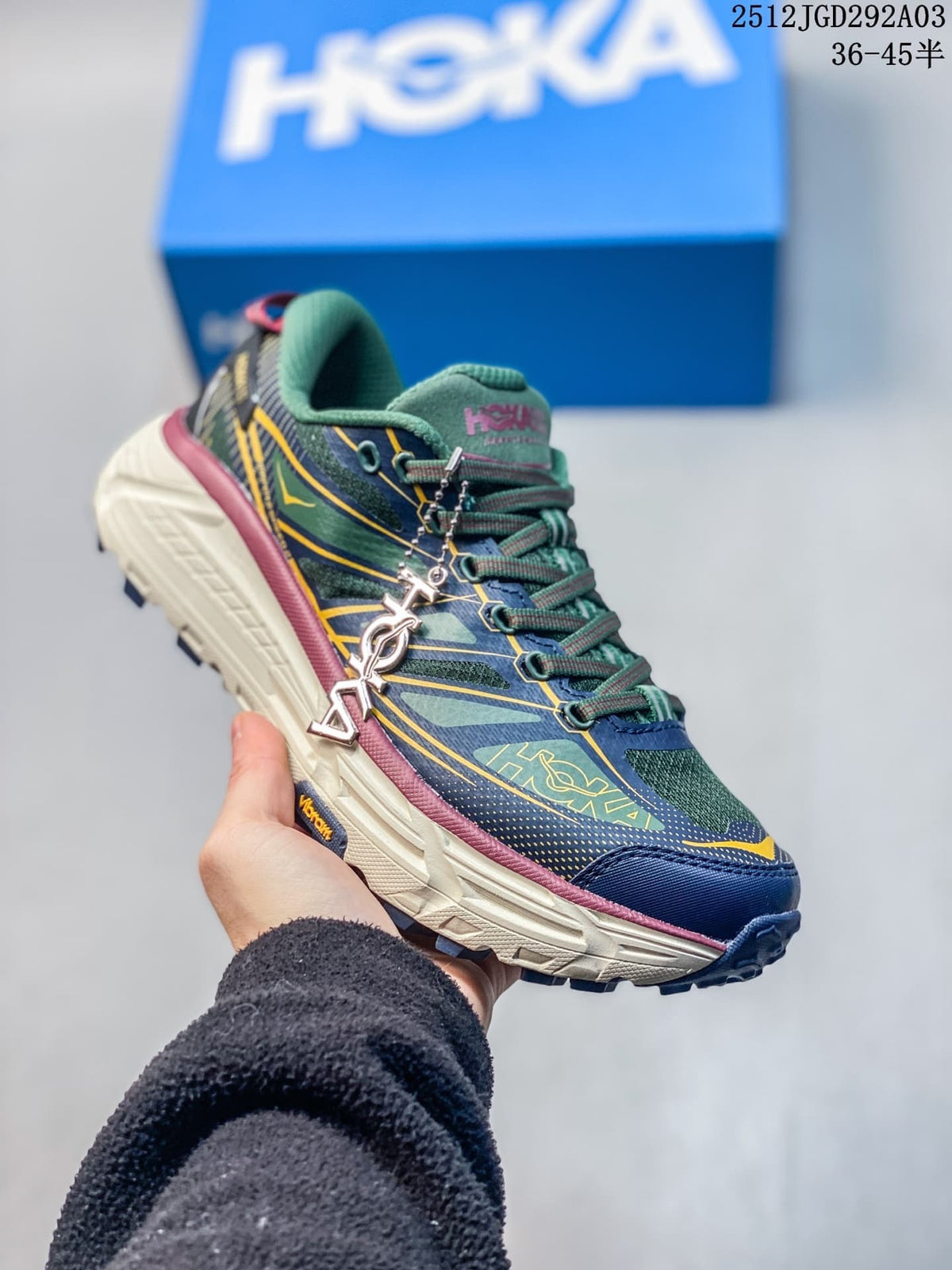Side view of a navy HOKA Mafate Speed 2 trail shoe with green and yellow details.