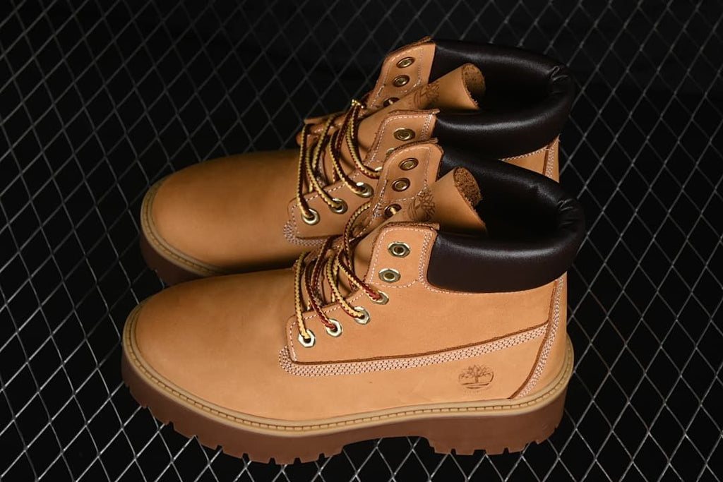 Pair of wheat-colored lace-up boots with dark padded collars and platform soles