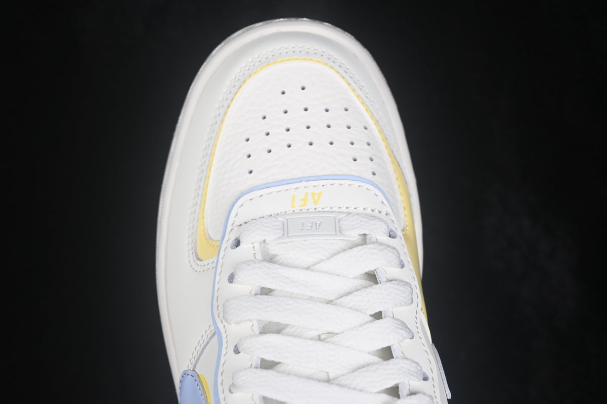 Top-down close-up of the perforated white toe box, layered trim, and white laces.