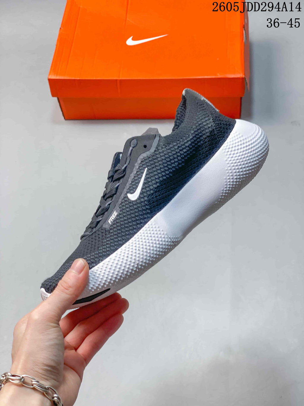 Side view of a charcoal Nike Free shoe showing the white sole and side logo