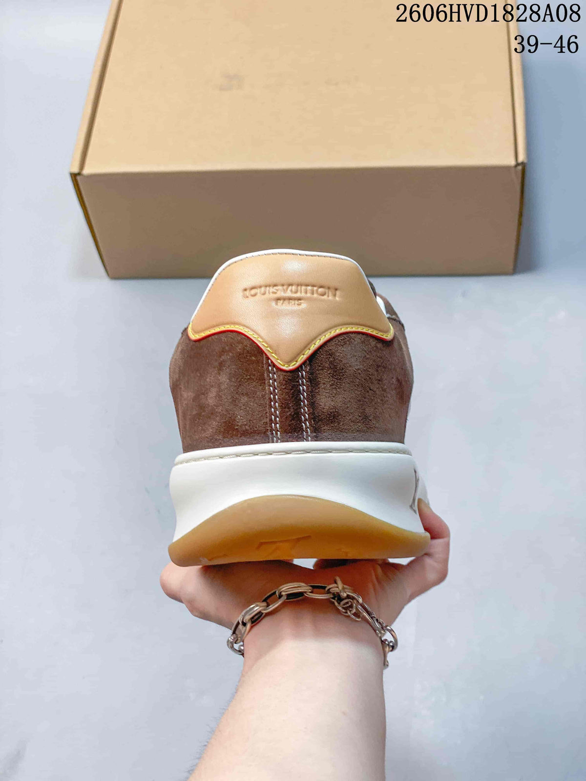 Rear view of a brown sneaker with a tan heel tab and white midsole