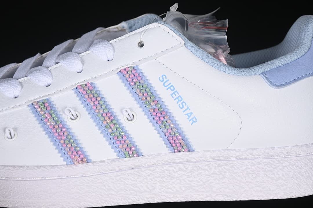 Close-up of pastel multicolor side stripes and light blue Superstar lettering