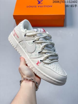White low-top sneaker held in front of an orange Louis Vuitton-marked shoe box, showing gray patterned laces, perforated toe panels, and side detailing.