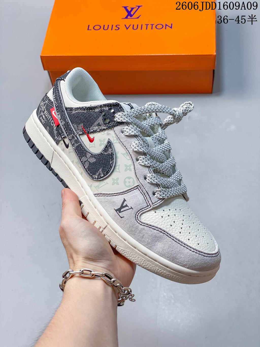 Angled side view of the cream and gray sneaker with printed panels and a dark patterned Swoosh