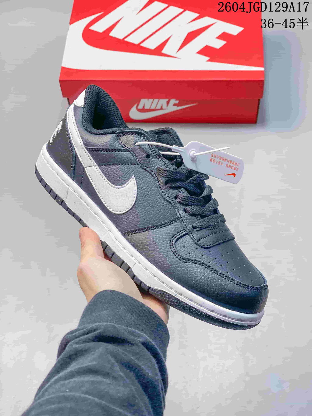 Close-up of a dark navy Nike Big Low sneaker with a white Swoosh and textured panels.