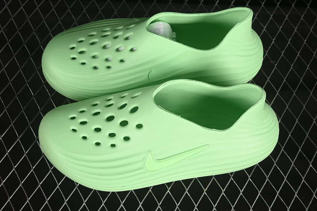 Pair of light green slip-on clogs with perforated uppers