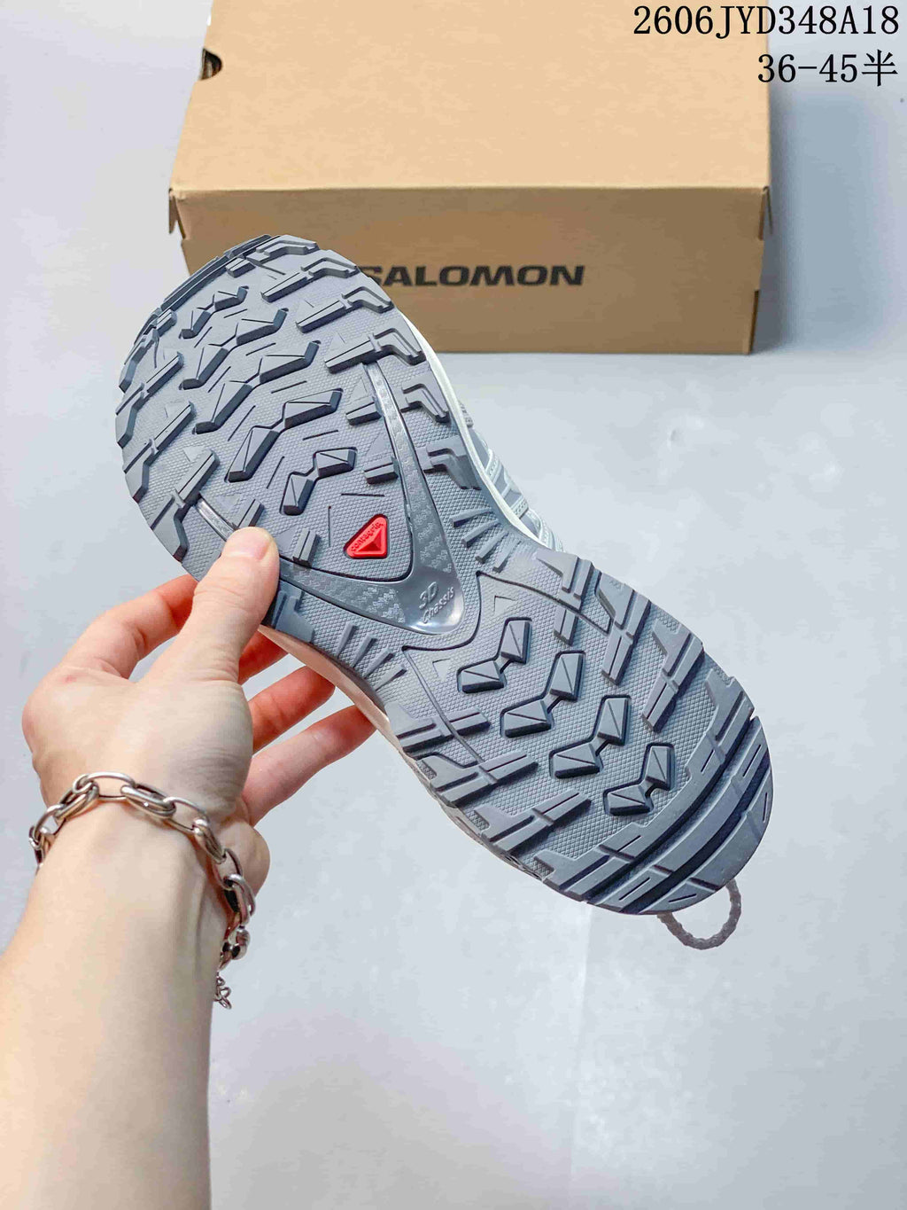 Close-up of the gray lugged outsole on a Salomon trail running shoe.