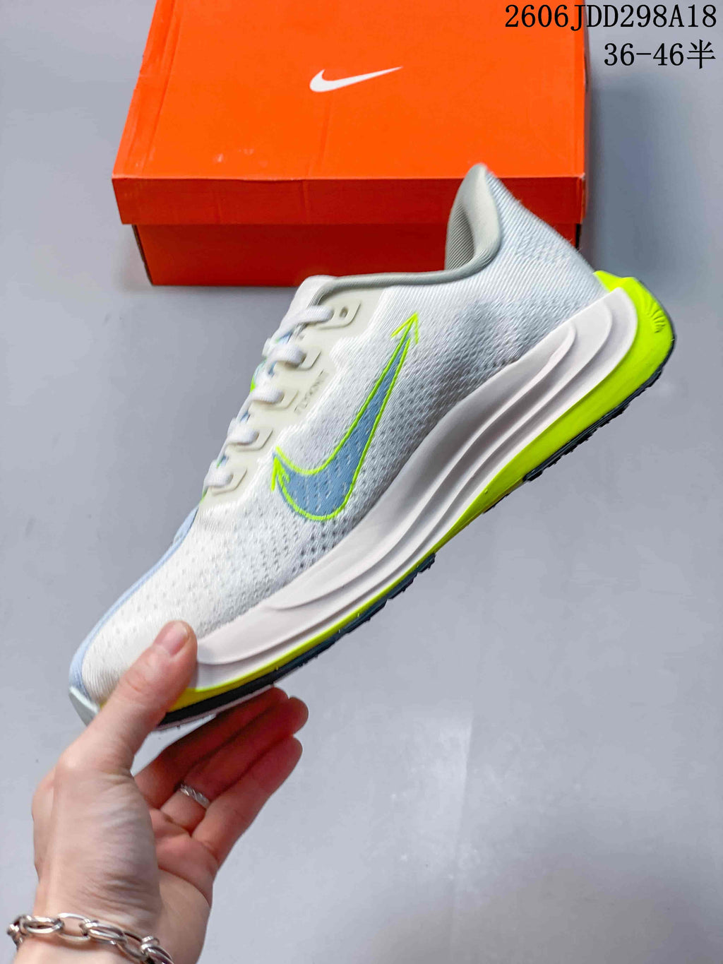 Side view of the light-colored running shoe with pale blue and bright volt accents