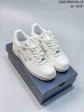 Pair of white low-top Nike Air Force 1 sneakers with metallic side and lace accents on a shoebox