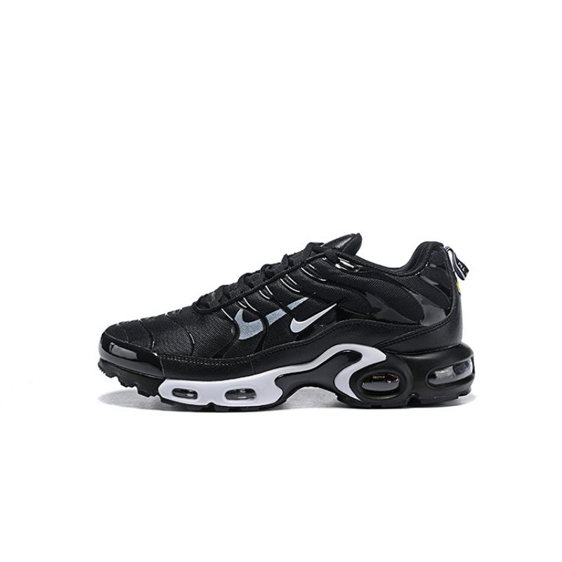 Black Nike Air Max Plus sneaker with a white sole and light swoosh accents.