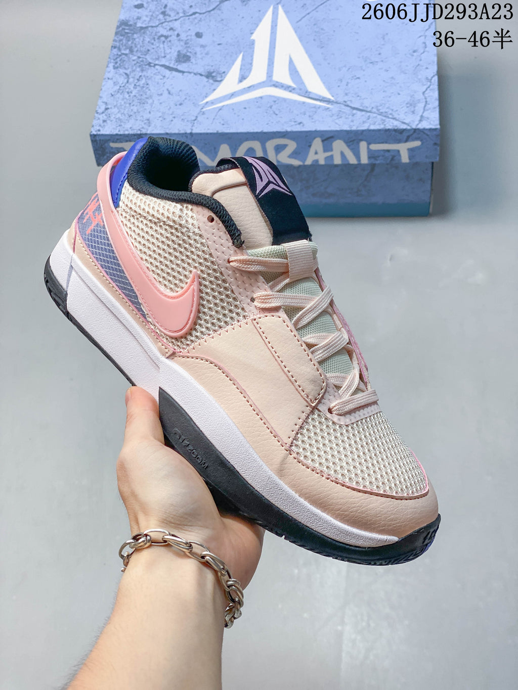 Angled side view of a Nike Ja 1 EP basketball shoe in pale pink, cream, blue, and dark charcoal.