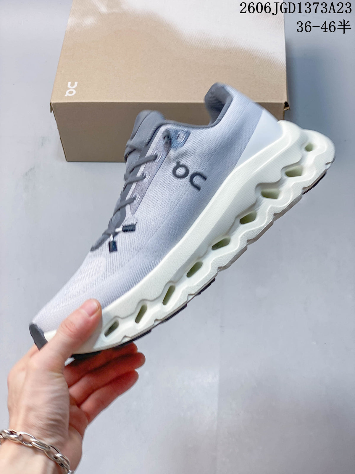 Side view of a gray On Cloudtilt Remix sneaker with an off-white sculpted sole