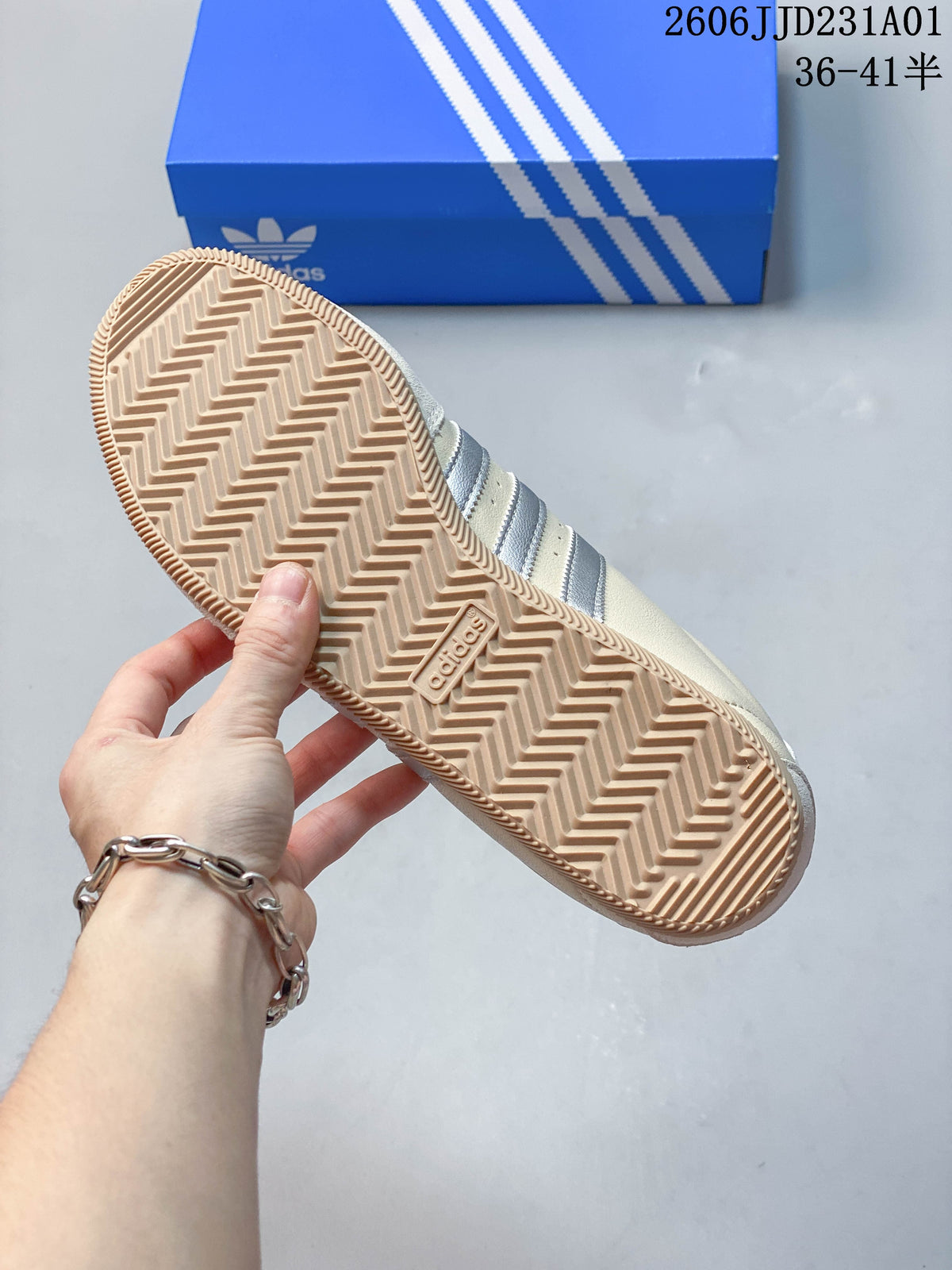 Gum-colored outsole with chevron tread on a cream Adidas Originals sneaker