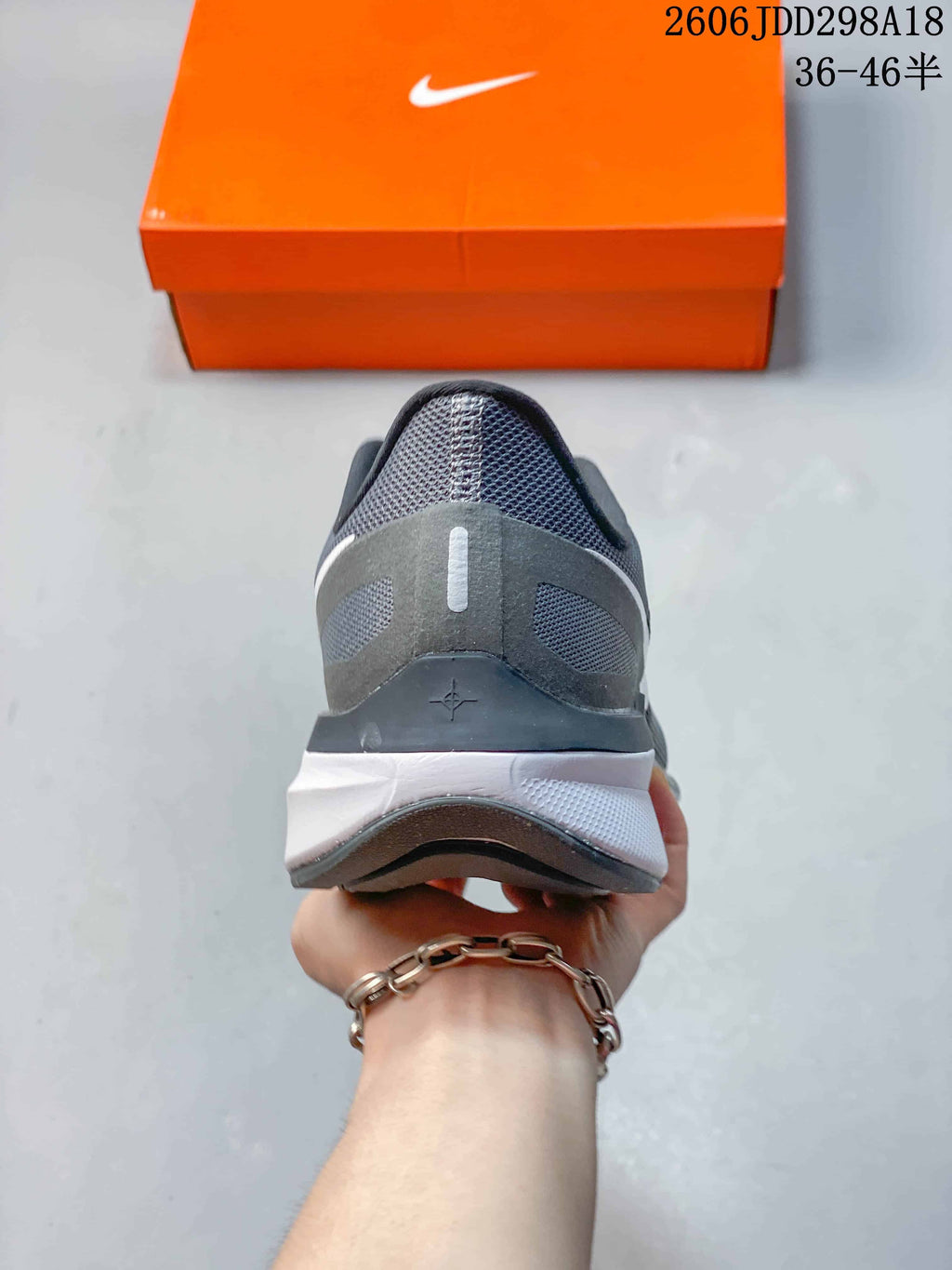 Rear view of a gray Nike running shoe showing the heel and midsole