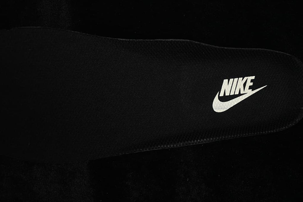 Close-up of a black insole with a Nike wordmark and Swoosh.