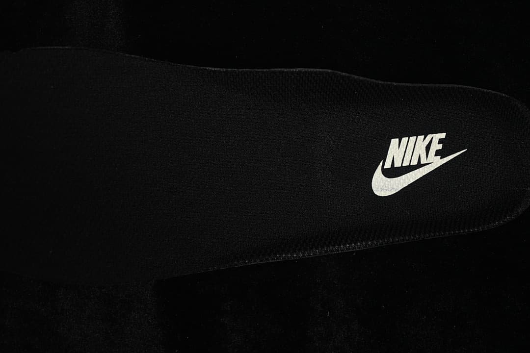 Close-up of a black insole with a Nike wordmark and Swoosh.