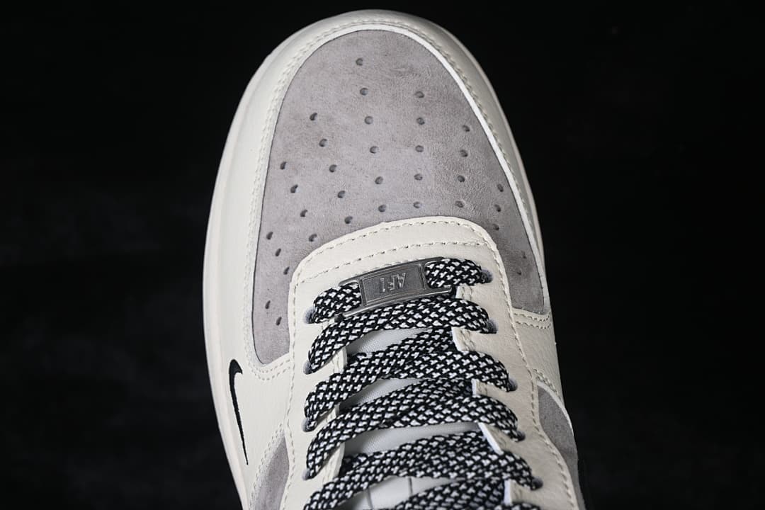 Top-down close-up of the perforated grey toe panel and patterned laces.