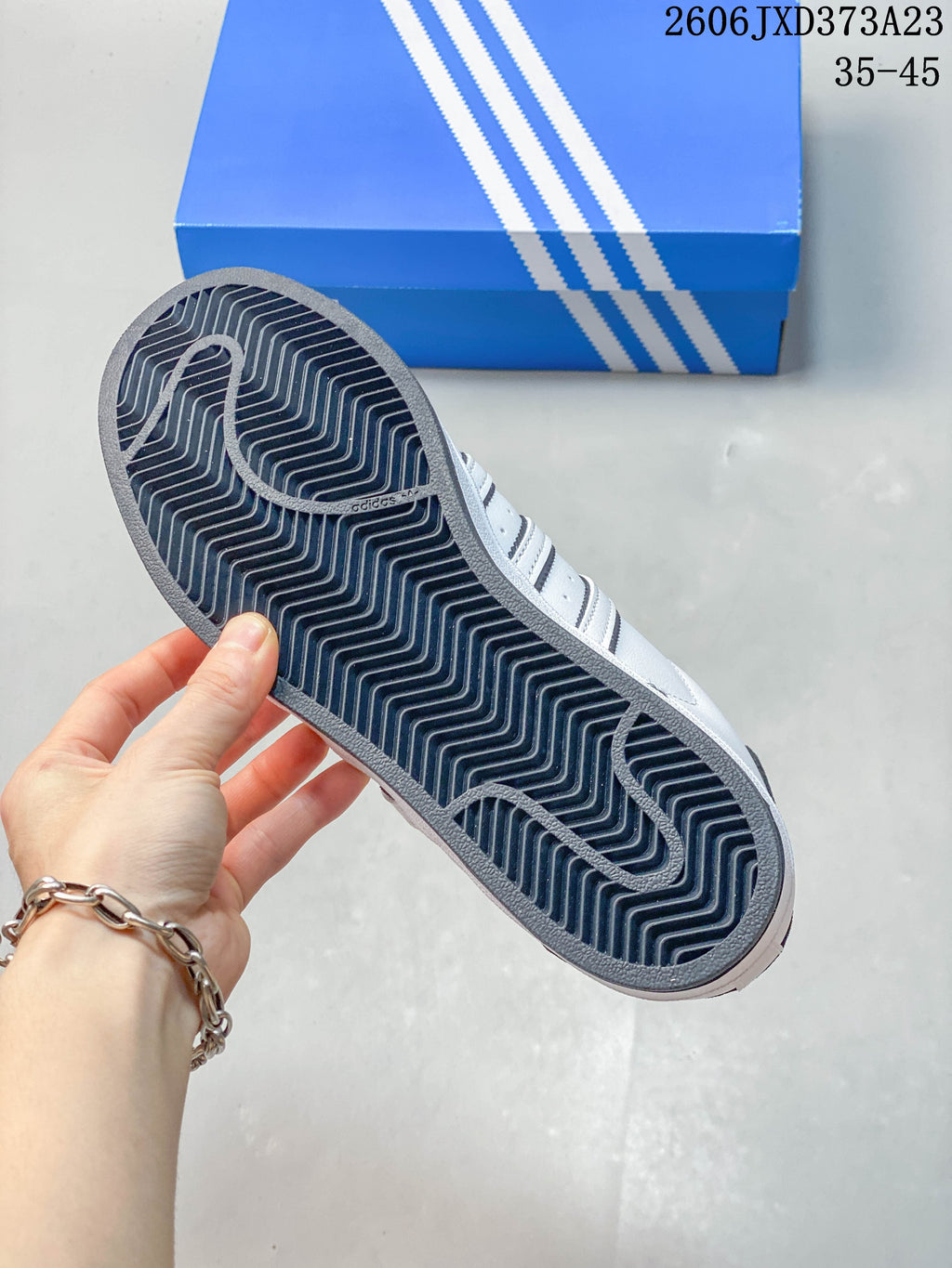 View of the dark patterned outsole on a white Superstar sneaker