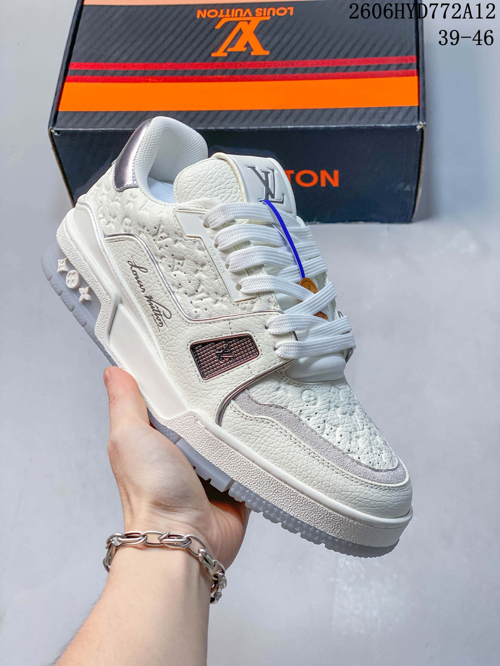 Angled view of a white sneaker showing its side details, textured panels, and silver-tone heel accent.