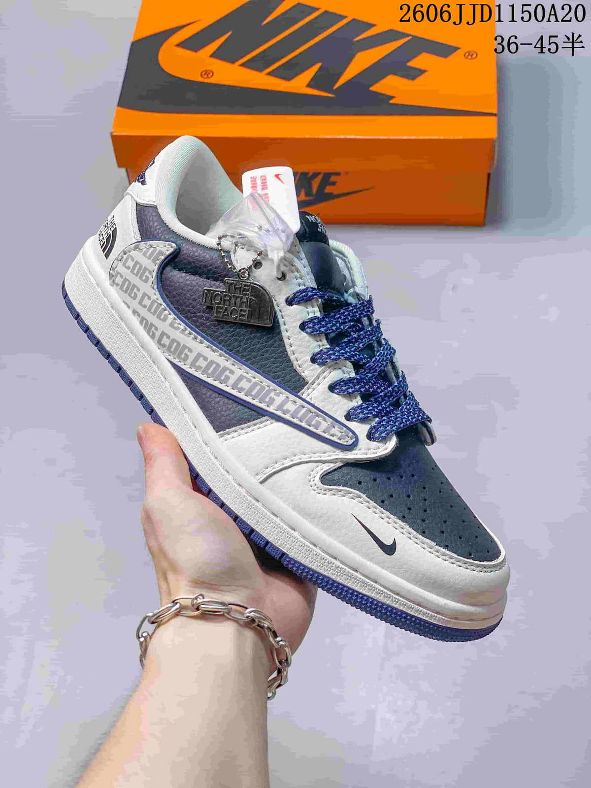 Angled side view highlighting navy panels, white overlays, blue laces, and side graphics.