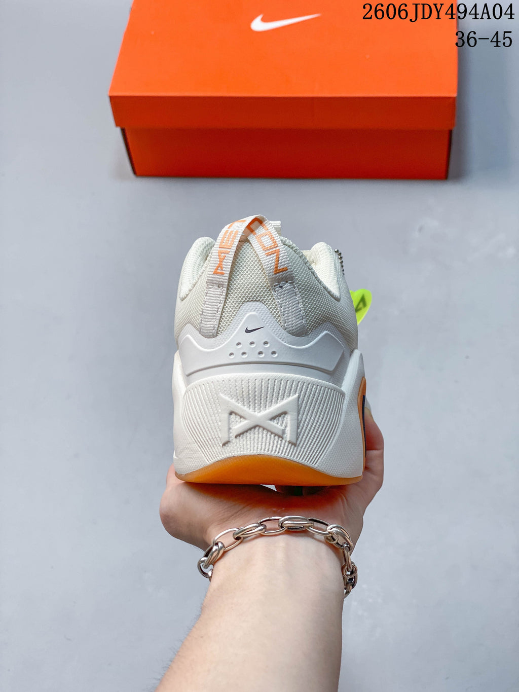 Rear view showing the heel construction and orange outsole accent.