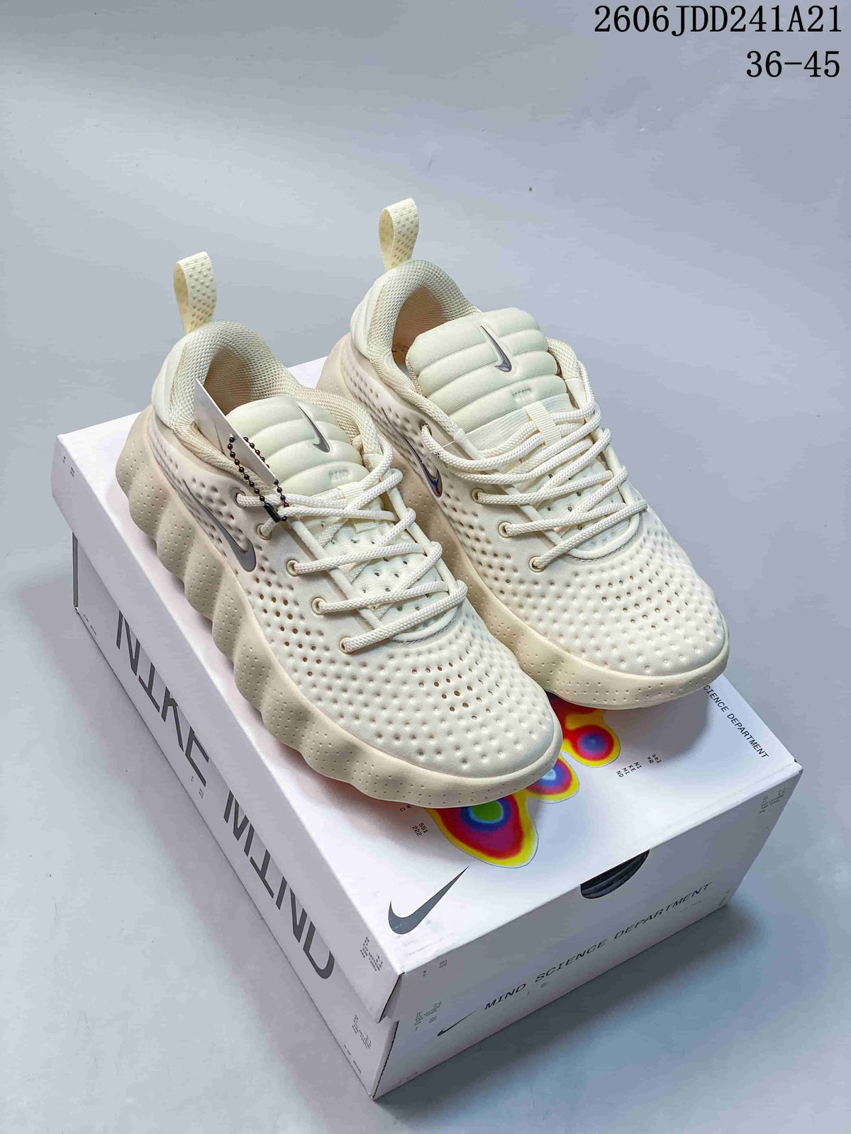 Pair of cream Nike Mind sneakers on a Nike Mind box