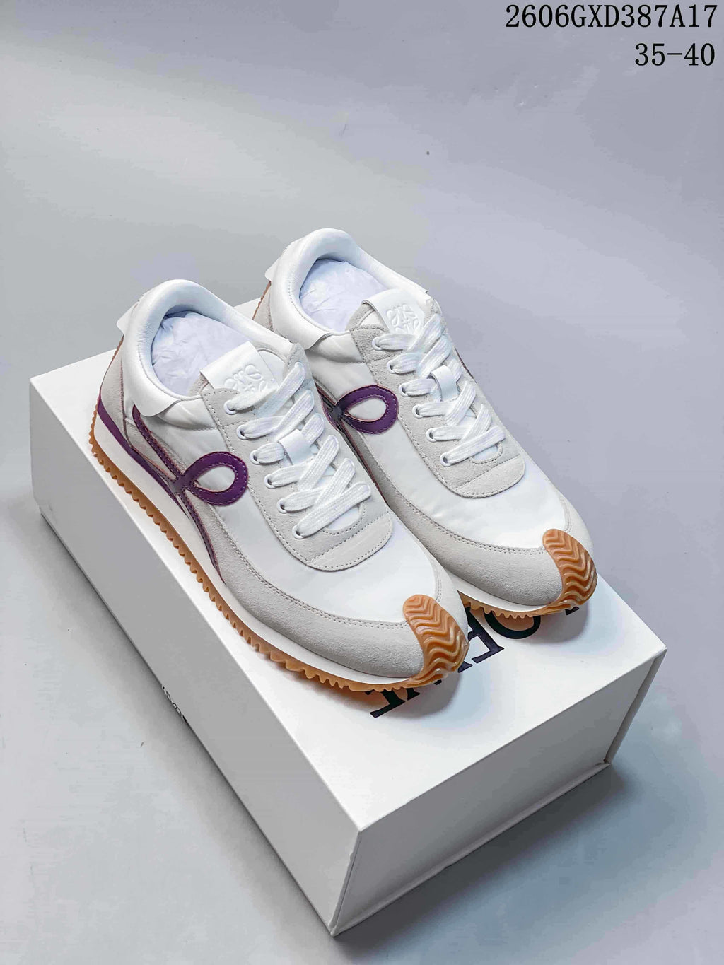 Pair of white and light gray lace-up sneakers with purple side accents and gum-colored soles