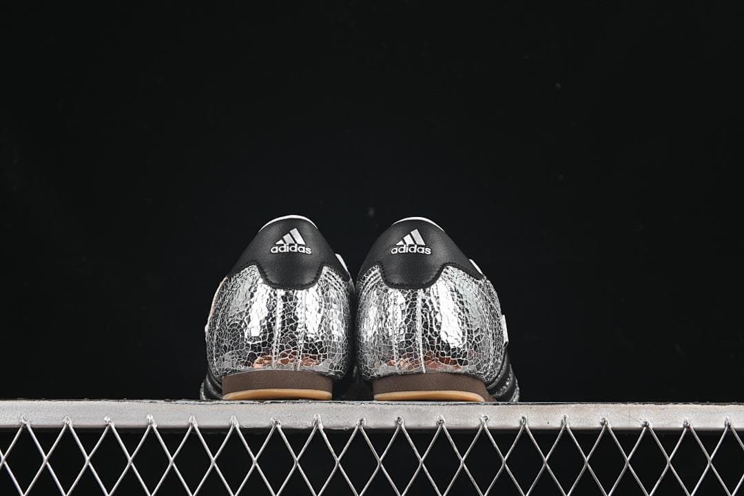 Back view of both shoes with black heel panels and silver patterned uppers.