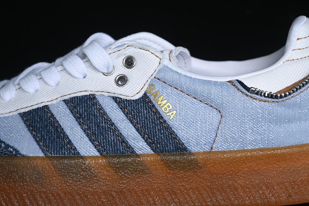 Close-up of blue panels, dark stripes, white laces, and gum sole