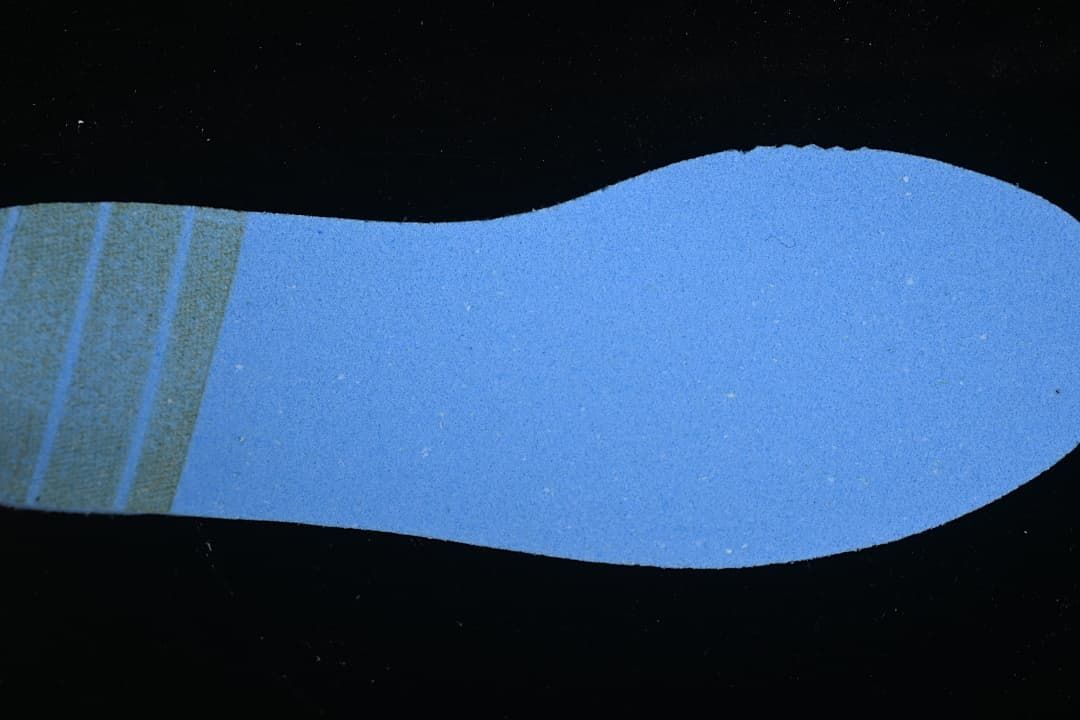 Blue shoe insert or insole component shown separately against a dark background.