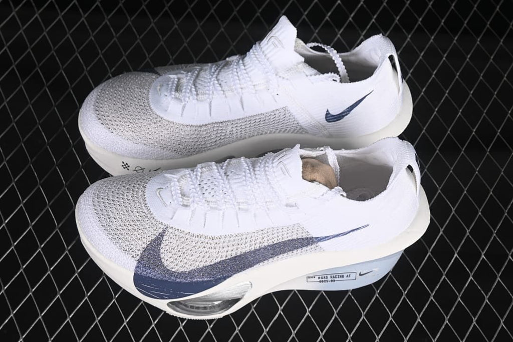 Pair of white Nike road racing shoes with navy accents