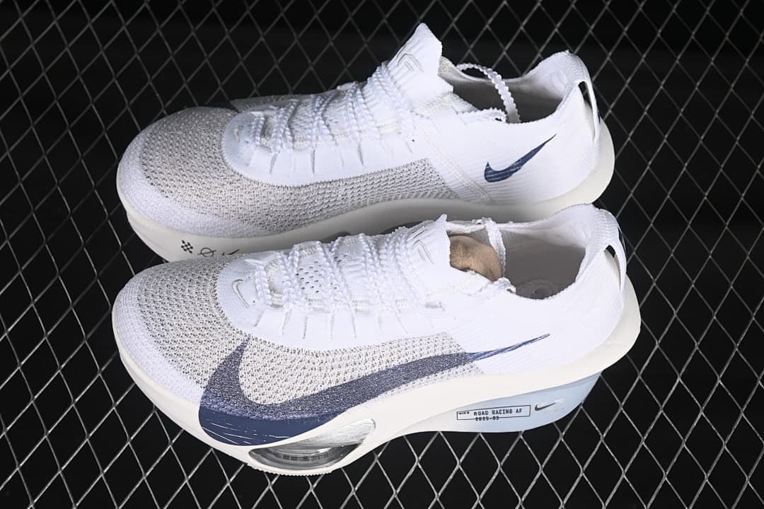 Pair of white Nike road racing shoes with navy accents