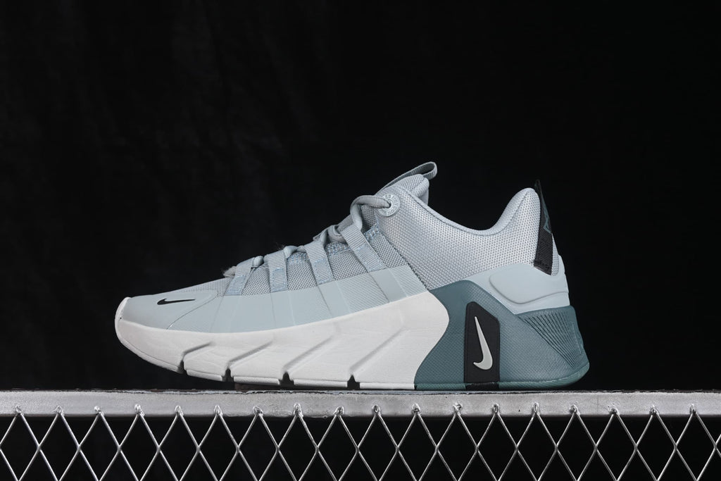 Side view of the gray sneaker showing the mesh upper, lace system, white midsole and teal heel.